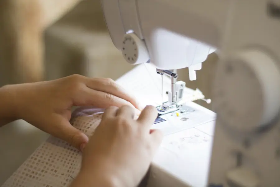 Manos cosiendo en una máquina doméstica
